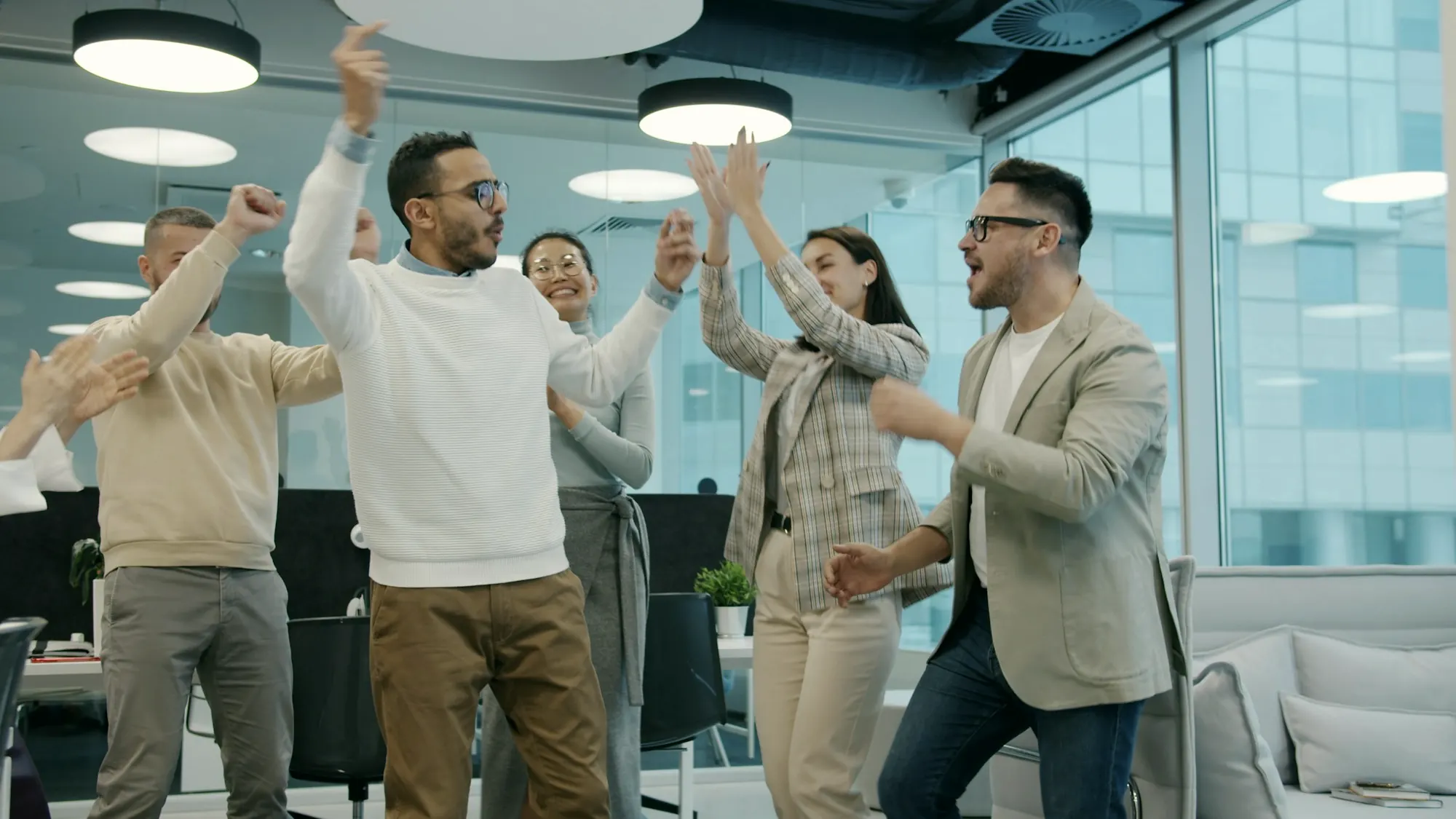 Colleagues celebrating together in a bright office
